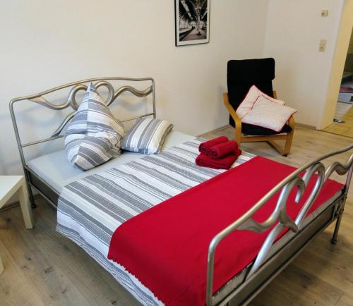 - une chambre avec un lit doté d'une couverture rouge et d'une chaise dans l'établissement feelathome, à Essen
