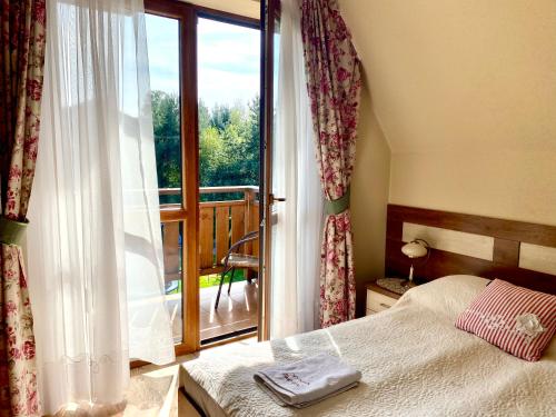 a bedroom with a bed and a large window at Pod Lipą 2 in Białka Tatrzańska