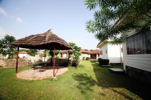 a large straw umbrella in a yard at Virat Resorts, Sariska Rajasthan in Bairāt