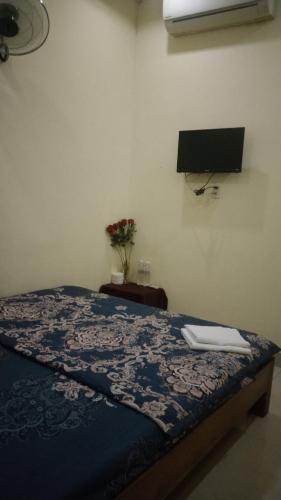 a bedroom with a bed and a tv on the wall at Nguyên Khôi in Thôn Dương Xuân Hạ