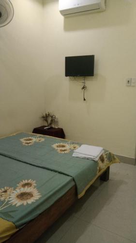 a bed in a room with a tv on the wall at Nguyên Khôi in Thôn Dương Xuân Hạ