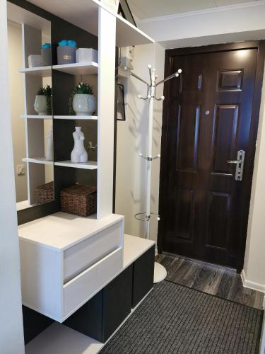 a bathroom with a closet with white shelves and a door at Jaama Apartment in Valga