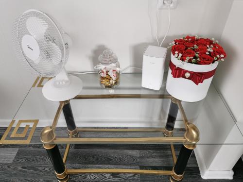 a glass table with a fan and a bouquet of roses at Jaama Apartement in Valga