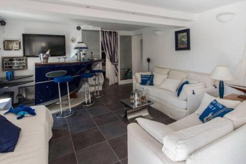 a living room with white couches and a tv at Dans villa spa hammam sauna piscine, 5 chambres in Juan-les-Pins