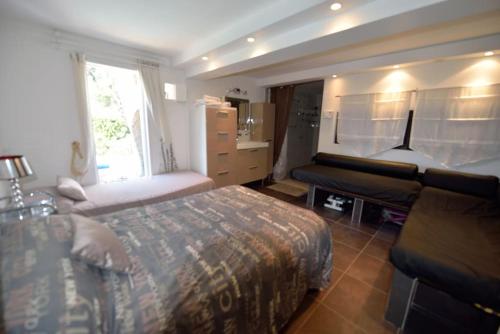 a large bedroom with a bed and a couch at Dans villa spa hammam sauna piscine, 5 chambres in Juan-les-Pins