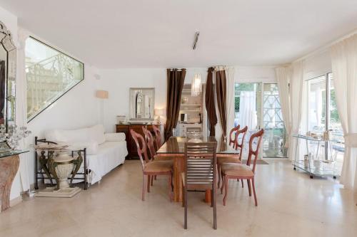 a living room with a table and chairs and a couch at Dans villa spa hammam sauna piscine, 5 chambres in Juan-les-Pins