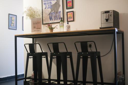 a bar with two stools under a table with a counter at LevonTLV in Tel Aviv