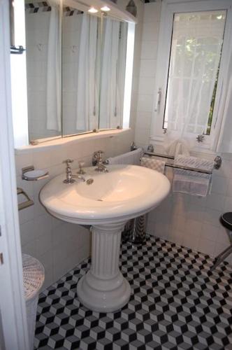 a white sink in a bathroom with a black and white floor at Dans villa spa hammam sauna piscine, 5 chambres in Juan-les-Pins
