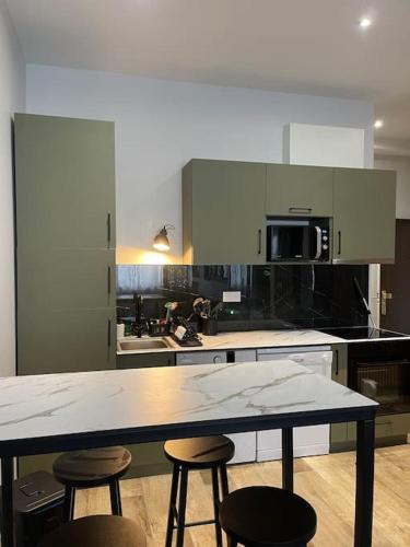 une cuisine avec une table et deux tabourets dans l'établissement The Place to be Lyon 7, à Lyon