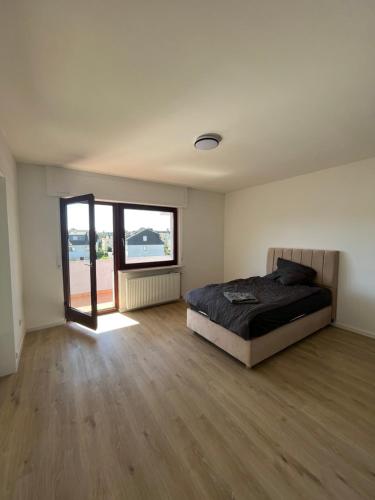 - une chambre avec un lit et une grande fenêtre dans l'établissement Möbliertes Apartment in Offenbach am Main - Zentrale Lage, à Offenbach-sur-le-Main