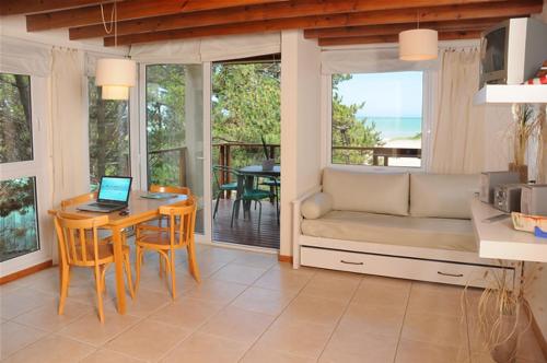 een woonkamer met een bank en een tafel met een laptop bij Apart El Mar in Mar de las Pampas