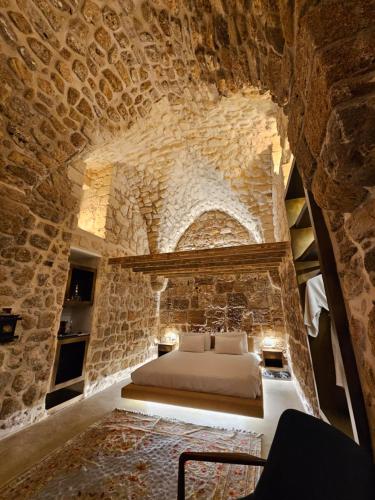 أكوتيكا بوتيك في عكا: غرفة نوم بسرير في جدار حجري
