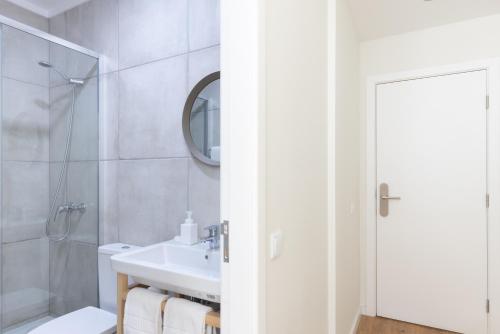 a bathroom with a sink and a toilet and a mirror at Lisbon Story Guesthouse in Lisbon