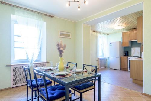 cocina y comedor con mesa y sillas en Oksana's Apartments, en San Petersburgo