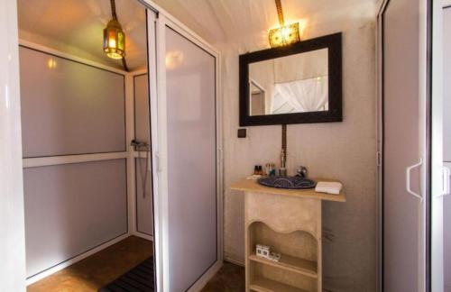 a small bathroom with a sink and a mirror at Riad family in Merzouga