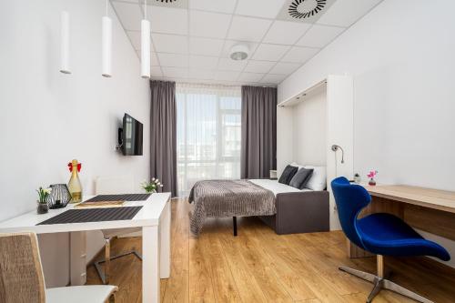 a hotel room with a bed and a desk and a table at Al Jerozolimskie 216 APART-WAWA in Warsaw