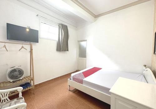 sypialnia z łóżkiem i telewizorem na ścianie w obiekcie OYO 1196 Le Vu Hotel w mieście Da Lat