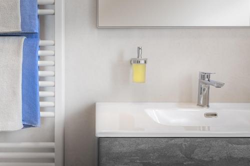 a bathroom with a white sink and a yellow soap dispenser at AZIENDA AGRICOLA MOSCHIONI in Cividale del Friuli