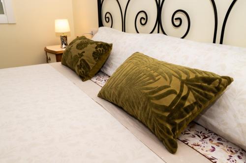 1 dormitorio con 2 camas con almohadas verdes en Los tres castells, en La Senia