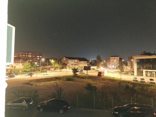 a city at night with cars parked in a parking lot at Elegantna oaza apartment in Banja Luka