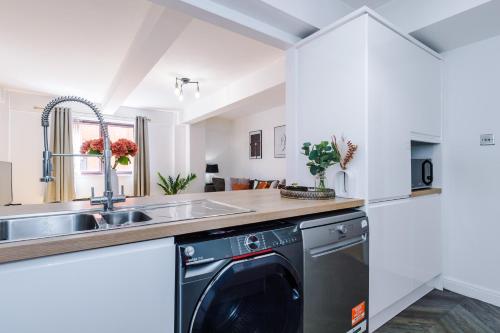 a kitchen with a sink and a dishwasher at Manchester City Centre 2 bed apartment in Manchester
