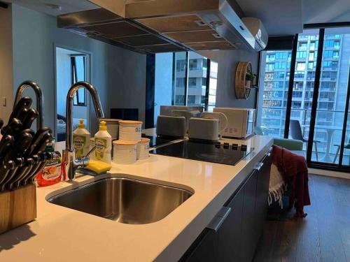a kitchen with a sink and a large window at City-view High Rise 2BR Apt w/Pool, Sauna Gym, Library near Southern Cross Station Melbourne CBD in Melbourne