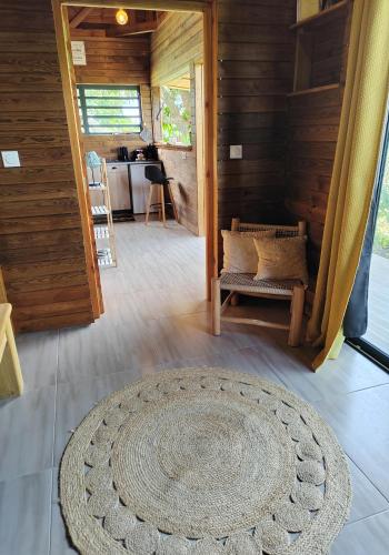 a living room with a rug on the floor at Odyssea Caraïbes Cottages & Spa in Saint-Louis