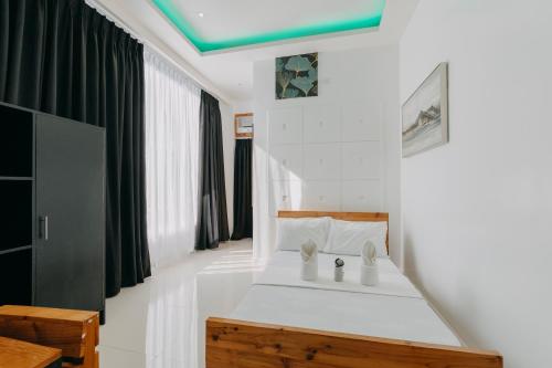 a bedroom with a white bed with a green ceiling at The Marc Vannelli Oslob in Oslob