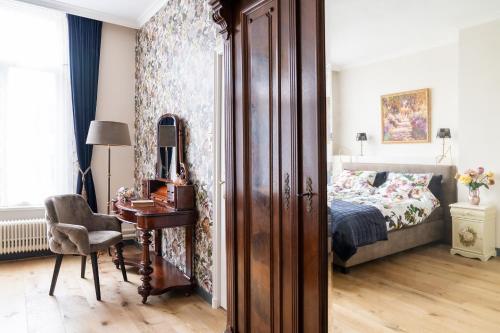 a bedroom with a bed and a desk with a chair at De Jonge Barones in Beetsterzwaag