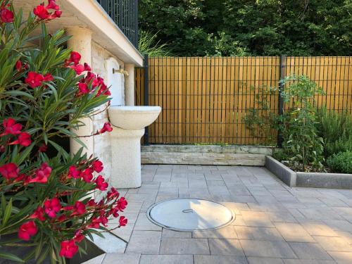 a patio with red flowers and a fence at Angel Boutique Home - Entire premium house in Laško