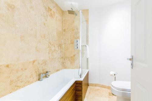 a bathroom with a tub and a sink and a toilet at Croft House - By Luxury Apartments in Cheltenham