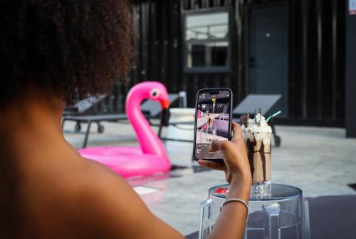 a woman taking a picture of a pink flamingo at Boxo Diani - Unique Beach Front Container Eco-Hotel in Diani Beach