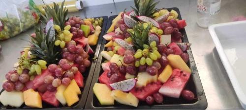 two trays of fruit sitting on top of a counter at Sunny Days Hotel in Ixia