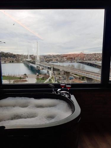 a bath tub in a window with a view of a bridge at Karaköy in Karaköy Hotel in Istanbul