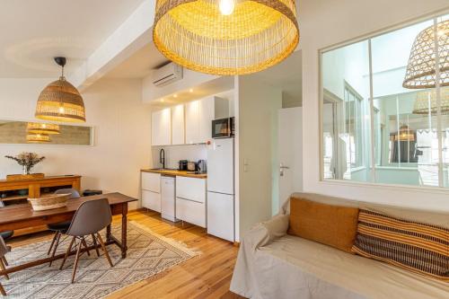 Il dispose d'une cuisine et d'un salon avec un canapé et une table. dans l'établissement Bordeaux Jardin Public : T3 Rénové Immeuble Pierre, à Bordeaux
