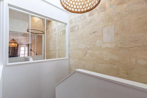 Cette chambre blanche dispose d'une fenêtre et d'un miroir. dans l'établissement Bordeaux Jardin Public : T3 Rénové Immeuble Pierre, à Bordeaux