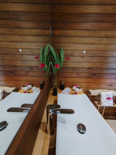 two white tables in a room with wooden walls at Odyssea Caraïbes Cottages & Spa in Saint-Louis