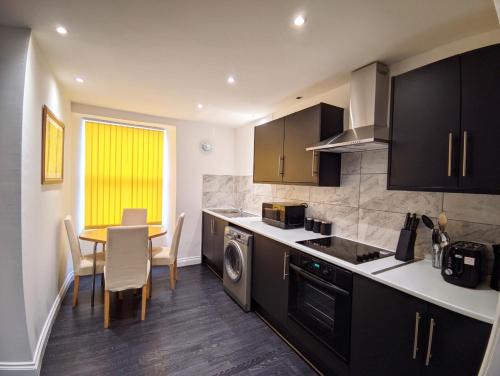 a kitchen with a table and a dining room at A&A Luxury Stay Olive St - City Centre Premium Stays in Sunderland