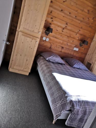 une chambre avec un lit et un plafond en bois dans l'établissement Chalet Regina, à Lanslebourg-Mont-Cenis