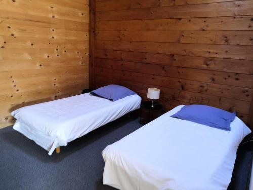 deux lits dans une chambre aux murs en bois dans l'établissement Chalet Regina, à Lanslebourg-Mont-Cenis