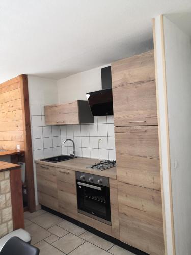 una cucina con mobili in legno e piano cottura con forno di Chalet Regina a Lanslebourg-Mont-Cenis