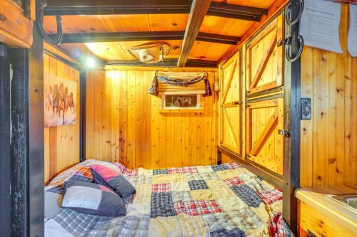 a bedroom with a bed in a wooden room at Sevierville Studio Cabin Rental with Private Hot Tub in Sevierville