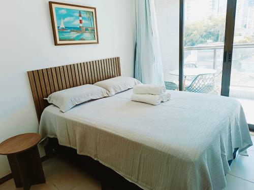 a bedroom with a bed with two towels on it at Barra Pinauna Studio in Salvador