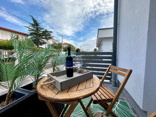 a bottle of wine sitting on a table on a balcony at Apartments Easy in Dramalj
