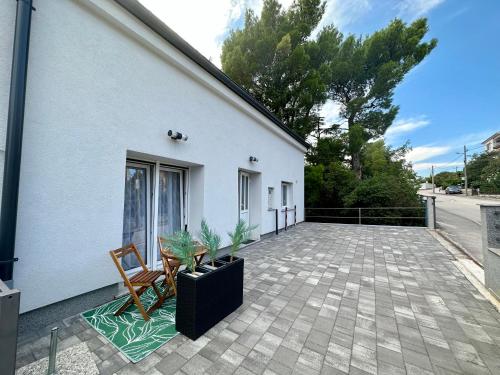 a white building with two chairs and a patio at Apartments Easy in Dramalj