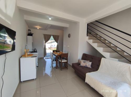 a living room with a couch and a staircase at Sobrado novo vista para o Cristo in Encantado