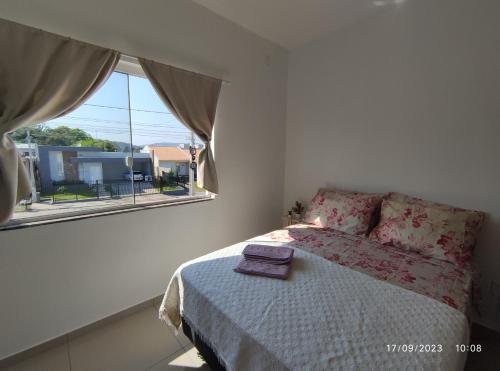 a bedroom with a bed and a window at Sobrado novo vista para o Cristo in Encantado