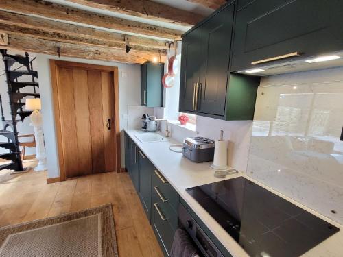 a kitchen with green cabinets and a counter top at The Manor Pen in Lenham