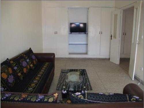 a living room with a couch and a tv at Joli Appartement in Oujda