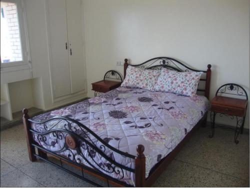 a bedroom with a bed with a quilt and two chairs at Joli Appartement in Oujda